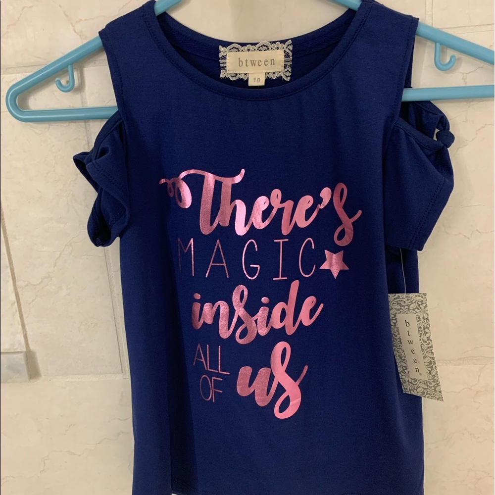 A blue slit sleeve top with pink holographic text